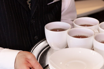 コーヒーを運んでいるウェイター