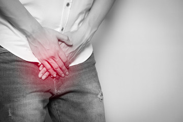 Male hands holding on middle crotch of trousers with prostate inflammation, Prostate cancer, Men's...