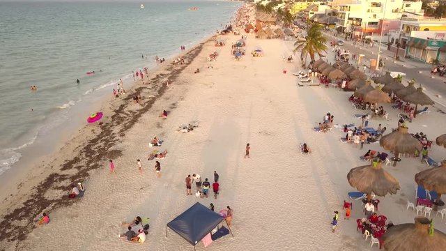 Toma aerea con drone en movimiento sobre playa con gente turista