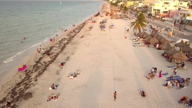 Toma aerea con drone en movimiento sobre playa con gente turista