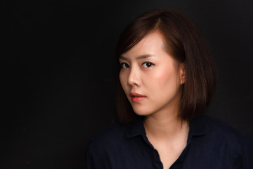 Close-up face of young asian lady demonstrating staring eye. Back view of beautiful woman looking away and showing her face in studio.