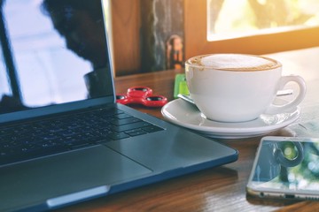 laptop and cup of coffee on table
