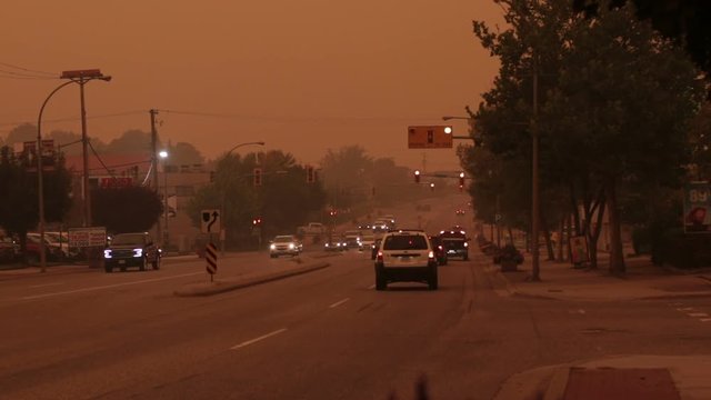 A busy highway is engulfed by a thick haze of smoke from nearby bc forest fires. Camera focus pulls into heavy bokeh effect.