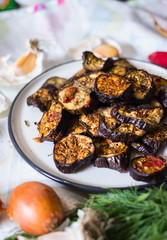 Roasted, grilled eggplants round slices with oregano herbs, spices baked on parchment paper in oven. Vegan vegetarian healthy lunch or dietary dinner.