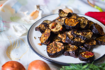 Roasted, grilled eggplants round slices with oregano herbs, spices baked on parchment paper in oven. Vegan vegetarian healthy lunch or dietary dinner.