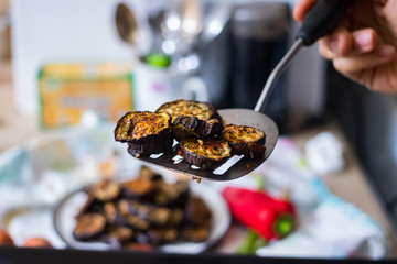 Take roasted, grilled eggplants round slices with spatula. Eggplants  with oregano herbs, spices baked on parchment paper in oven. Vegan vegetarian healthy lunch or dietary dinner.
