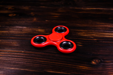 Red fidget spinner on wooden desk