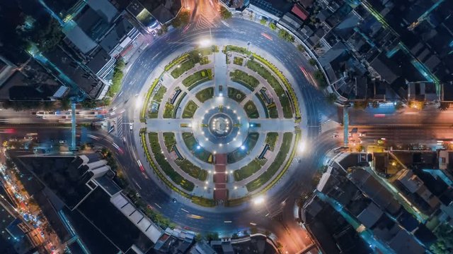 timelapse of night city traffic on 4-way stop street intersection circle roundabout in bangkok, thailand. 4K UHD horizontal aerial view.