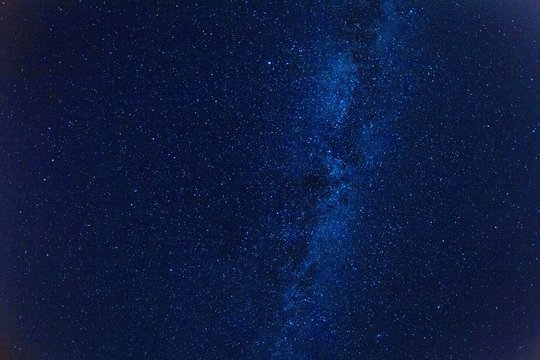 Mleczna droga na gwiaździstym na ciemnym niebieskim niebie