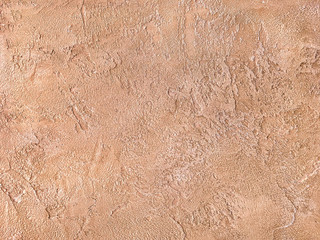 Old orange wall covered with uneven plaster. Texture of vintage shabby sand brick surface, closeup.