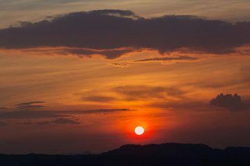 Sunset with silhouette of big mountain in summer
