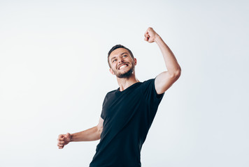 Handsome man with arms up celebrating success - obrazy, fototapety, plakaty