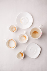 Many Empty coffee cups after drink on white background, trendy minimal monochrome concept, lazy sleepy morning closeup