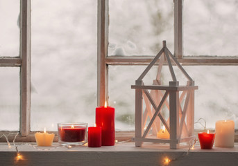 wooden lantern on windowsill on background winter landscape