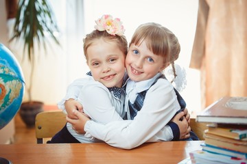 Two schoolgirls hug