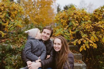 Fototapeta premium Family with a son having fun sitting outdoors in autumn