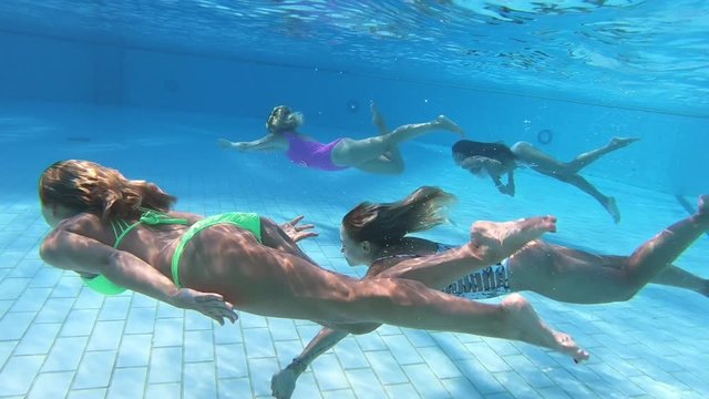People dive under blue water snorkeling in pool , slow motion