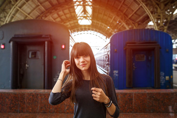portrait of a beautiful woman standing at the railway station near the train