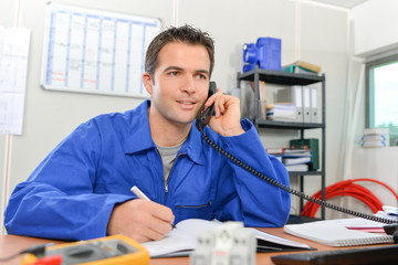 Man in overalls on telephone