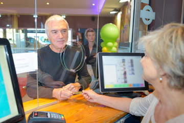 Man buying ticket through service hatch