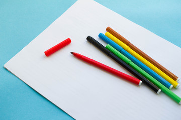 colored pens, pencils on a blue background. day of knowledge