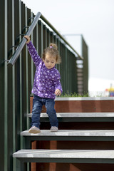 Little girl going down some stairs outdoors
