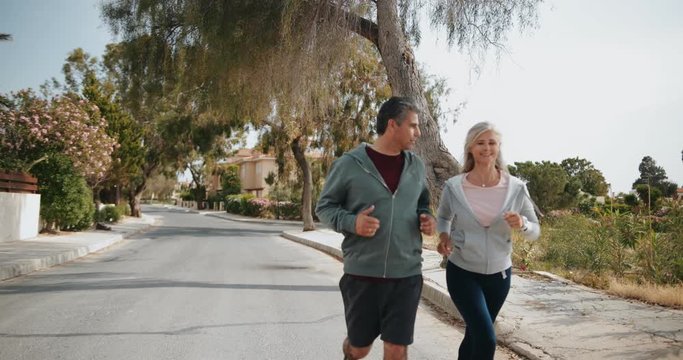 Happy multi-ethnic senior couple having fun running together