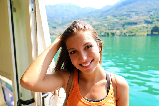 Cheerful young woman looking at the camera on ship. Cruise ship vacation woman enjoying her holiday on travel at sea.