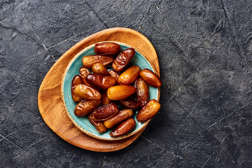Dried dates fruits on plate. Top view of pitted dates.