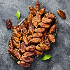 Dried dates fruits on plate with copy space. Top view.