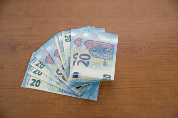 Many 20 euro banknotes on a wood table