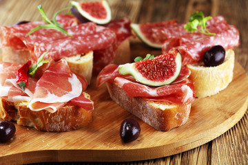 Sandwich with prosciutto or salami or crudo. Antipasti gourmet bruschetta snack.