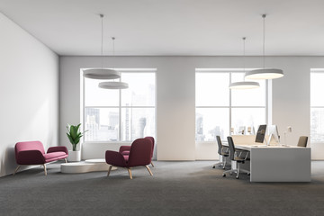 Computer tables in white office, sofa side view