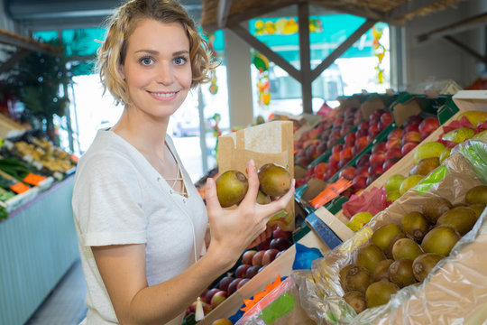 woman with bag buying apples at grocery store