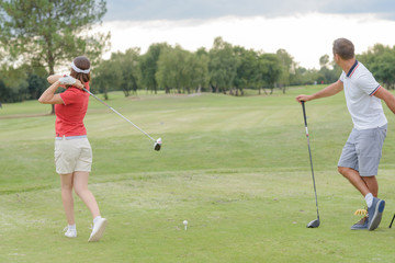 Obraz premium couple playing a round of golf on a green