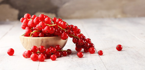 Fresh red currants on light rustic table. Healthy summer fruits