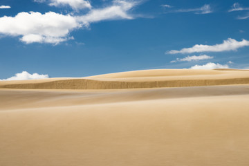 Fototapeta na wymiar sand dunes against blue sky and clouds in Leba, Poland,