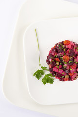 Salad with beets. Vinegret is a traditional Russian salad made from beets and vegetables. The background is white. Copy space. Macro. Vertical shot.