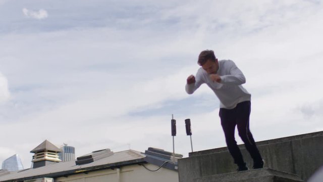 Young male doing parkour and jumping and running away, in slow motion