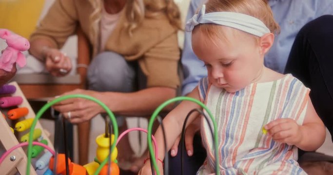 Multi-generation family playing with girl and toys on the floor