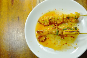 grilled squid dressing spicy sauce on white plate