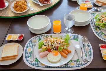 american breakfast on wood table.American breakfast with egg, sausage, bread and vegetable,Top view shot.