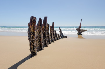 Rusted remains of a shipwreck on a beautiful, sandy beach on the Sunshine Coast, Queensland, Australia.