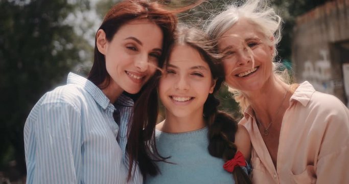 Portrait of smiling three-generation family of women outdoors in summer