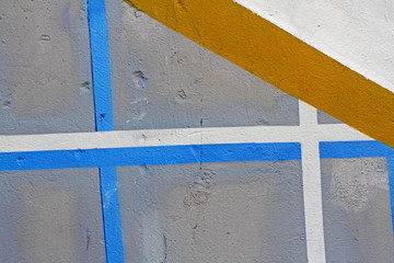 Fototapeta premium Colorful (grey, blue, white and yellow) painted wall with cracks as background or texture