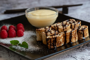 banan pancake sushi dessert with dip and chocolate syrup