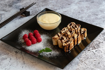 banan pancake sushi dessert with dip and chocolate syrup