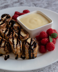 banan pancake sushi dessert with dip and chocolate syrup
