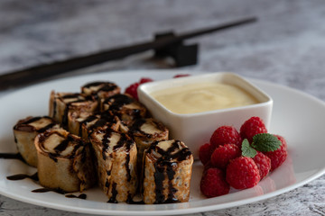 banan pancake sushi dessert with dip and chocolate syrup