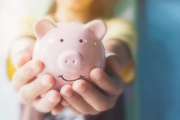 Fotobehang Female hand holding piggy bank. Save money and financial investment © Monster Ztudio